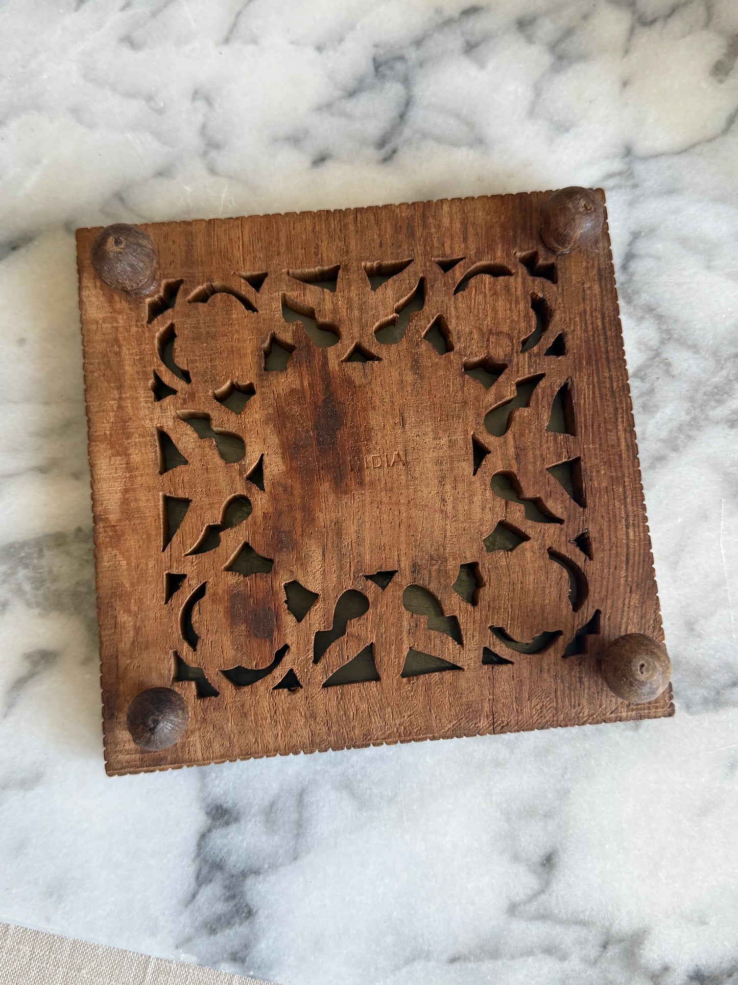 Hand carved wooden trivet with brass floral inlay