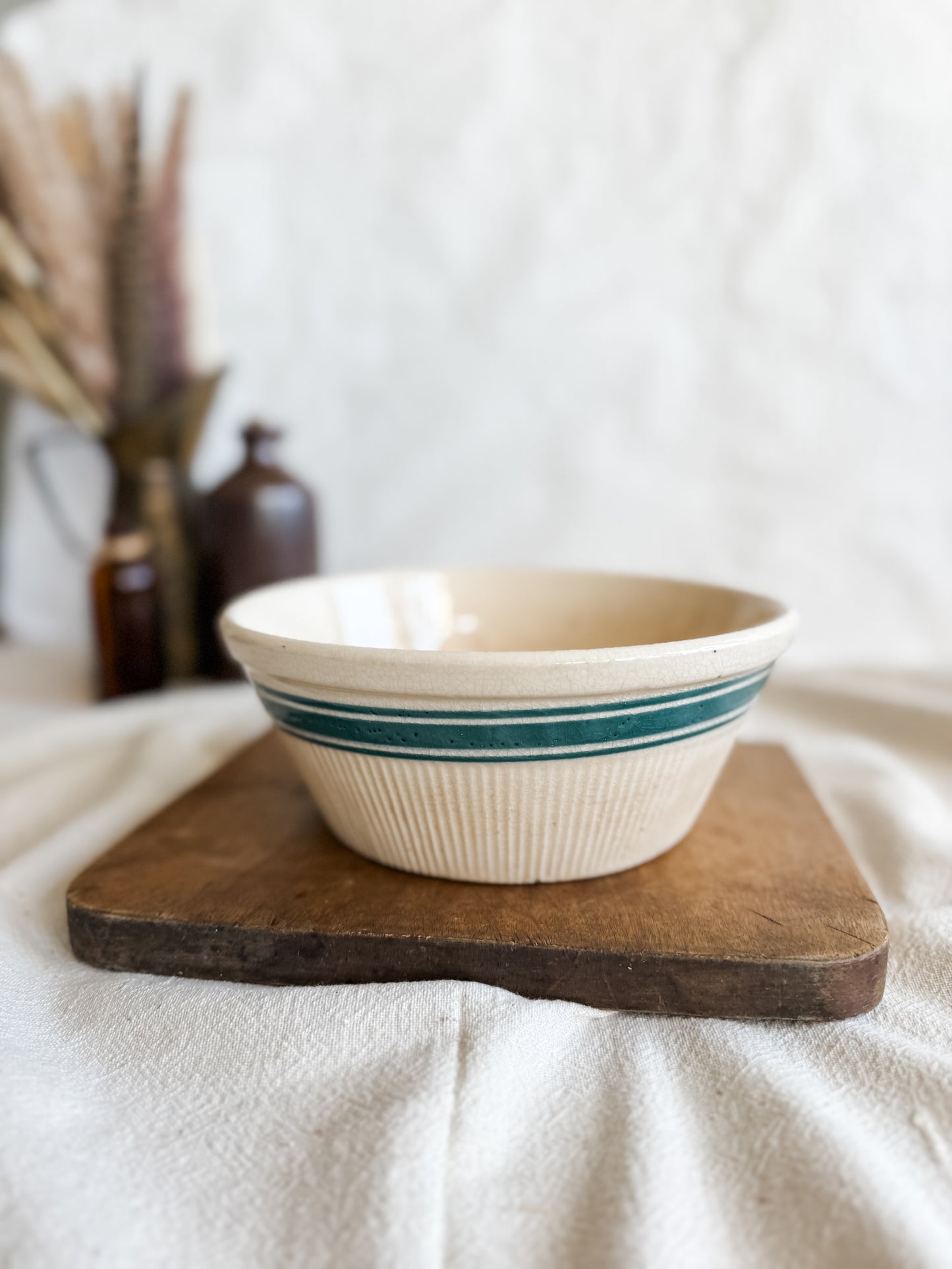 Stained and crazed antique bowl with teal stripe.