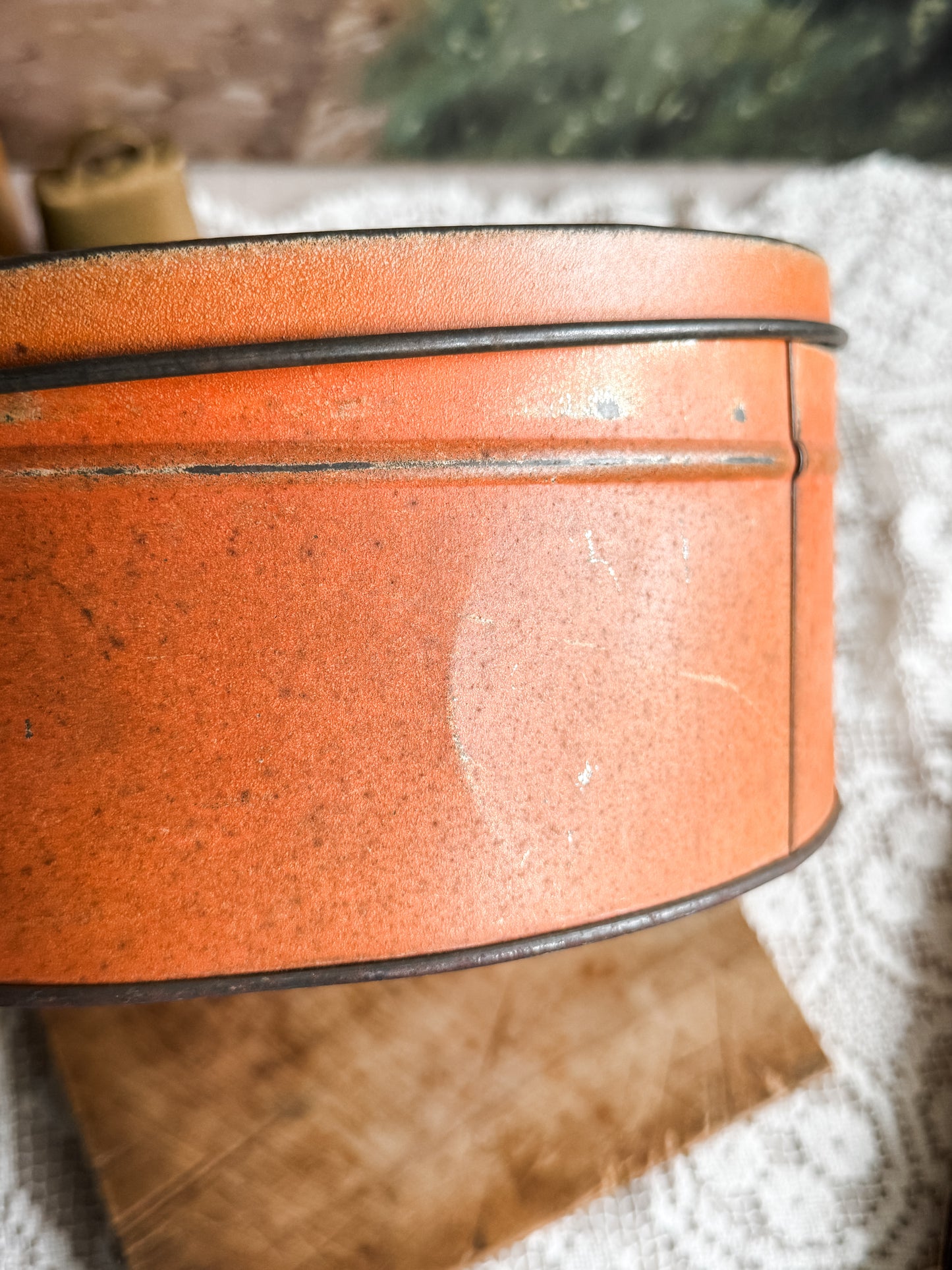 Large weathered orange tin with courting scene