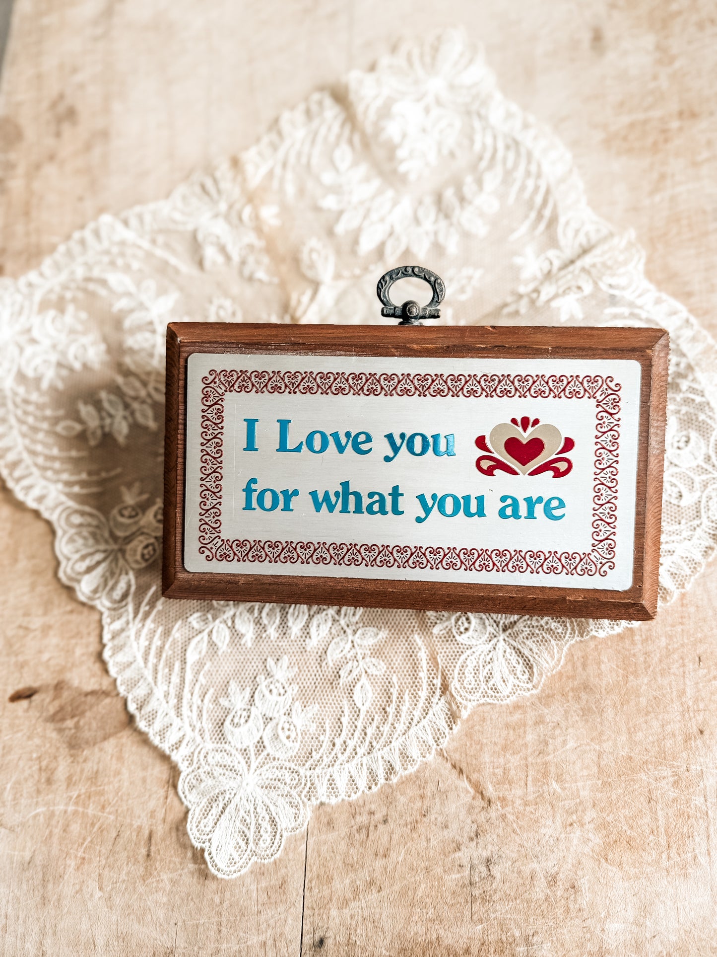 Small vintage wooden plaque that says “I love you for what you are.”