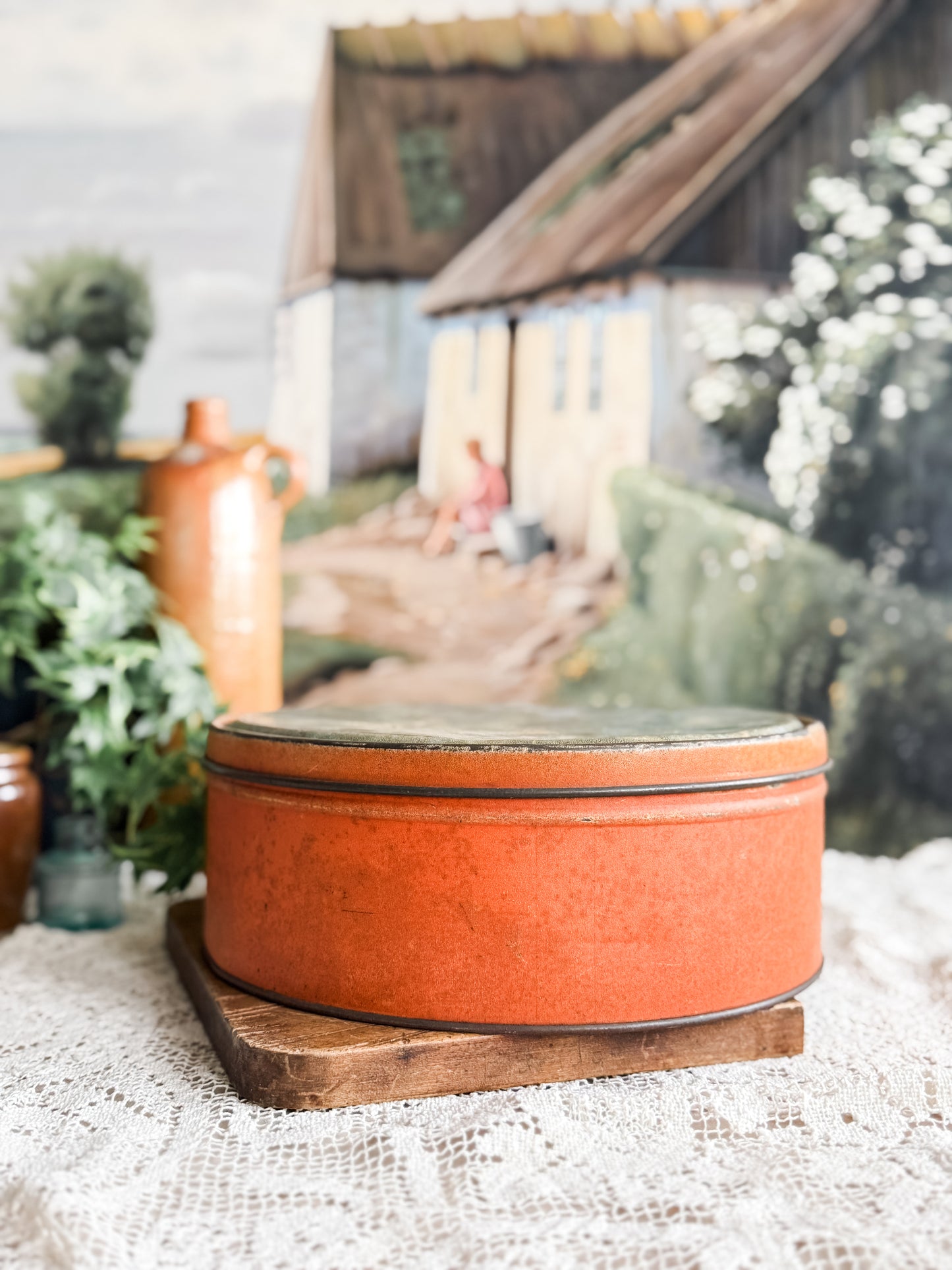 Large weathered orange tin with courting scene