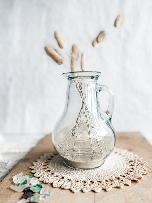 Glass pitcher with embossed sailing ship