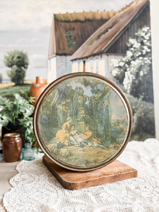 Large weathered orange tin with courting scene